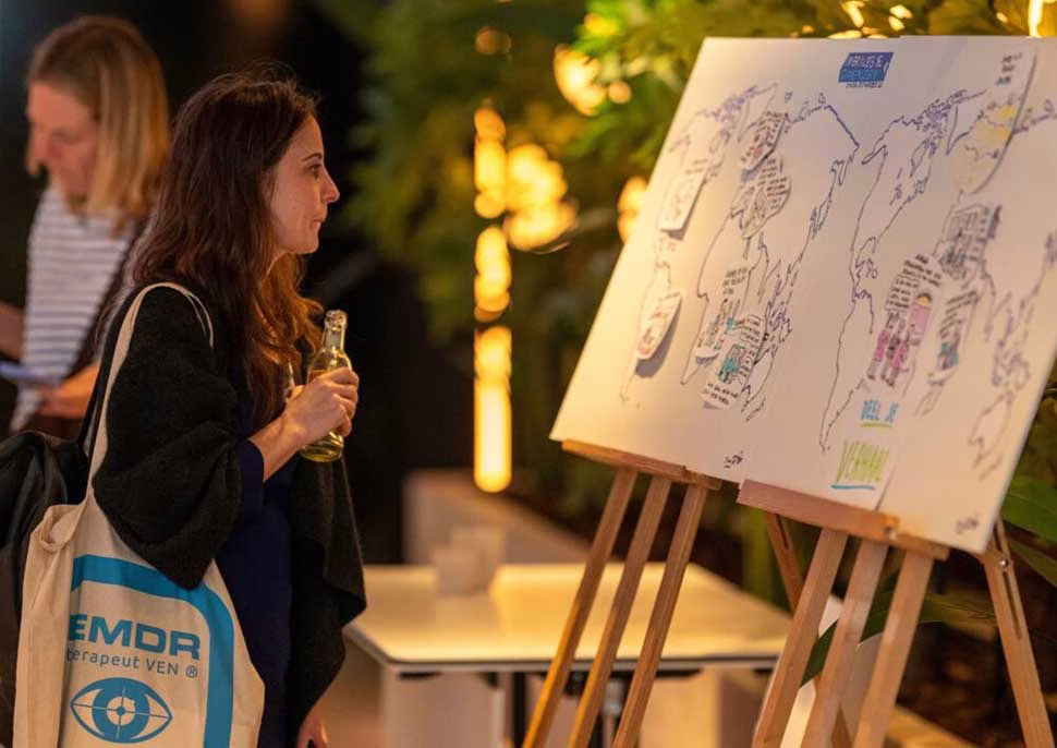 Bezoeker bekijkt live getekende wereldkaart tijdens het EMDR Congres 2026